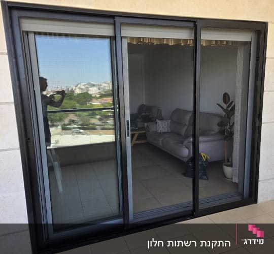 דלת הזזה מזכוכית עם השתקפות נוף